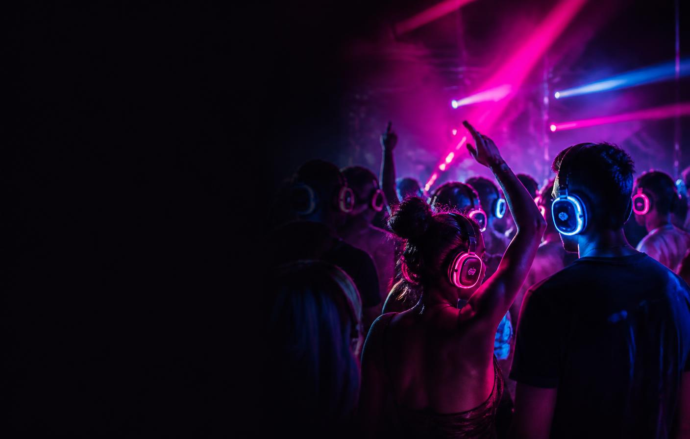 Silent disco crowd in glowing pink and blue LED headphones — 10% off midweek silent disco hire in Devon